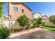 Home backyard showcasing stone patio and artificial grass framed with plants at 9476 Milkweed Canyon Ave, Las Vegas, NV 89166