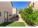 Serene backyard featuring lush greenery, artificial turf, and a stone patio area at 9476 Milkweed Canyon Ave, Las Vegas, NV 89166