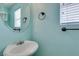 Powder room with a stylish circular mirror and modern fixtures at 9476 Milkweed Canyon Ave, Las Vegas, NV 89166