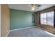 Bedroom with a ceiling fan and large window with curtains, filled with natural light at 9476 Milkweed Canyon Ave, Las Vegas, NV 89166