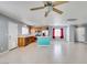 Living room featuring tile floors, a ceiling fan, kitchen with island, and stainless steel appliances at 9476 Milkweed Canyon Ave, Las Vegas, NV 89166