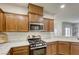Kitchen featuring stainless steel appliances, wood cabinets, and marble countertops at 9535 Vega Carpio Ave, Las Vegas, NV 89178