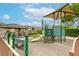 Community playground with slide, sunshade, and secure fencing for recreation and enjoyment at 9535 Vega Carpio Ave, Las Vegas, NV 89178