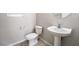 This half bathroom features a modern white pedestal sink, toilet, and a small window for natural light at 9750 Maple Sugar Leaf Pl, Las Vegas, NV 89148