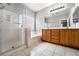 Bright bathroom features a glass shower, soaking tub, tile flooring, and double sink vanity with ample cabinet space at 9750 Maple Sugar Leaf Pl, Las Vegas, NV 89148
