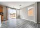 Open dining area features modern light fixture, sliding glass door to a balcony, and gray wood-look floors at 9750 Maple Sugar Leaf Pl, Las Vegas, NV 89148