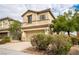 Inviting two-story home with a two-car garage, desert landscaping, and a neutral stucco facade at 9750 Maple Sugar Leaf Pl, Las Vegas, NV 89148