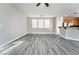 Open-concept living space with modern gray flooring, neutral walls, and views of the kitchen at 9750 Maple Sugar Leaf Pl, Las Vegas, NV 89148