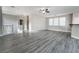 Spacious living room with gray wood-look flooring, a ceiling fan, and plenty of natural light at 9750 Maple Sugar Leaf Pl, Las Vegas, NV 89148