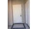 A well-lit white front door and door mat to unit 1140 provides a simple, welcoming entry at 9975 Peace Way # 1140, Las Vegas, NV 89147