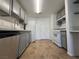 Galley kitchen with gray cabinets, white appliances, quartz countertops, tile floors, and recessed lighting at 9975 Peace Way # 1140, Las Vegas, NV 89147