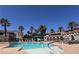 Community pool area featuring refreshing blue water, swaying palm trees, and comfortable lounge seating at 9975 Peace Way # 1140, Las Vegas, NV 89147