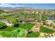 Expansive aerial view of a beautiful golf course community featuring lush landscaping, ponds, and a clock tower at 10241 Premia Pl, Las Vegas, NV 89135