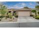 Charming single-story home featuring a two-car garage and desert landscaping with a tiled roof at 10241 Premia Pl, Las Vegas, NV 89135