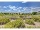 Expansive golf course view from behind a low brick wall, showcasing lush greens and distant homes at 10241 Premia Pl, Las Vegas, NV 89135