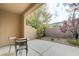 Covered patio with seating area and low-maintenance desert landscaping along the brick wall at 10241 Premia Pl, Las Vegas, NV 89135