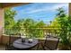 Relaxing balcony area with a round table, chairs, green scenery, and wrought iron railing at 10500 Pine Pointe Ave # 206, Las Vegas, NV 89144