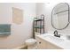 Bright bathroom features a white vanity, decorative shelving, and oval mirror at 10500 Pine Pointe Ave # 206, Las Vegas, NV 89144