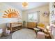 Charming Bedroom featuring a crib, changing table, and cozy seating area bathed in natural light at 10500 Pine Pointe Ave # 206, Las Vegas, NV 89144