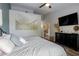 Stylishly staged bedroom features neutral tones, a ceiling fan, and a decorative dresser with a mounted television at 10500 Pine Pointe Ave # 206, Las Vegas, NV 89144