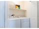 A tidy laundry room with a side-by-side washer and dryer, and overhead storage at 10500 Pine Pointe Ave # 206, Las Vegas, NV 89144