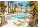 Beautiful swimming pool area with palm trees, lounge chairs, and well-manicured landscaping at 10500 Pine Pointe Ave # 206, Las Vegas, NV 89144