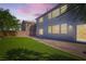 Evening shot of the backyard, featuring lawn area, concrete patio, and block wall at 10654 Robin Hill Ave, Las Vegas, NV 89129