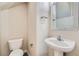 Powder room featuring a pedestal sink, framed mirror, and a toilet at 10654 Robin Hill Ave, Las Vegas, NV 89129