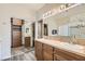 Main bathroom features dual sinks, framed mirrors, tile countertops, walk-in closet, and shower at 10654 Robin Hill Ave, Las Vegas, NV 89129