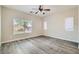 Spacious bedroom with wood-look flooring, large windows, and neutral walls at 10654 Robin Hill Ave, Las Vegas, NV 89129
