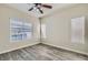 Bright bedroom with wood-look flooring, large windows, blinds, ceiling fan, and neutral walls at 10654 Robin Hill Ave, Las Vegas, NV 89129