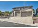Two-story home with a two-car garage and long driveway, complemented by minimalist landscaping at 10654 Robin Hill Ave, Las Vegas, NV 89129