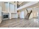 Open-concept living room with soaring ceilings, wood-look floors, a staircase, and fireplace feature at 10654 Robin Hill Ave, Las Vegas, NV 89129