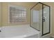 Bathroom showcasing a relaxing soaking tub and a modern glass-enclosed shower area with natural light at 10858 Morning Frost St, Las Vegas, NV 89179