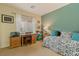 Inviting bedroom with a serene green accent wall, a cozy bed, and a dedicated workspace with a desk at 10858 Morning Frost St, Las Vegas, NV 89179