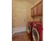 Bright laundry room featuring red washer and dryer and natural finish cabinets for storage solutions at 10858 Morning Frost St, Las Vegas, NV 89179