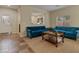 Bright living room featuring two blue sofas, a wooden coffee table, and tile flooring at entry at 10858 Morning Frost St, Las Vegas, NV 89179