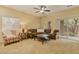 Comfortable living room with plush carpeting, ceiling fan, and access to outdoor patio at 10858 Morning Frost St, Las Vegas, NV 89179