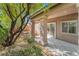 Covered patio featuring concrete tiling, neutral stucco, and manicured landscaping including a mature shade tree at 10858 Morning Frost St, Las Vegas, NV 89179