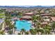 An elevated view of a luxurious community pool with a hot tub surrounded by lush landscaping and palm trees at 1108 Via Della Curia, Henderson, NV 89011