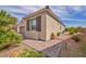 A tan one-story home is shown with a well-kept side yard and desert landscaping at 1108 Via Della Curia, Henderson, NV 89011