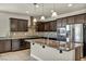 Gourmet kitchen featuring stainless steel appliances, dark wood cabinets, and granite countertops at 1108 Via Della Curia, Henderson, NV 89011