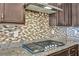 Modern kitchen featuring granite countertops, a stylish backsplash, and stainless steel gas range at 1108 Via Della Curia, Henderson, NV 89011
