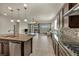 Open-concept kitchen flows into the living area, featuring granite countertops, tile flooring, and stainless steel appliances at 1108 Via Della Curia, Henderson, NV 89011