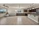 An open-concept living space is featured with dark cabinetry, a kitchen island and stainless steel appliances at 1108 Via Della Curia, Henderson, NV 89011