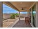 Relaxing covered patio with ceiling fan, dining furniture, and desert landscaping in the backyard at 1108 Via Della Curia, Henderson, NV 89011