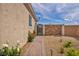 Gated side yard featuring desert landscaping with flower bushes and a patterned brick walkway at 1108 Via Della Curia, Henderson, NV 89011