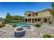 Expansive backyard with a large pool, spa, fire pit, and lush landscaping, perfect for outdoor enjoyment at 12122 High Country Ln, Las Vegas, NV 89138