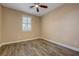 Comfortable bedroom with wood-look floors, a ceiling fan and bright, shuttered window at 12122 High Country Ln, Las Vegas, NV 89138