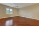 Large bedroom with wood floors, ceiling fan, and a window with plantation shutters at 12122 High Country Ln, Las Vegas, NV 89138